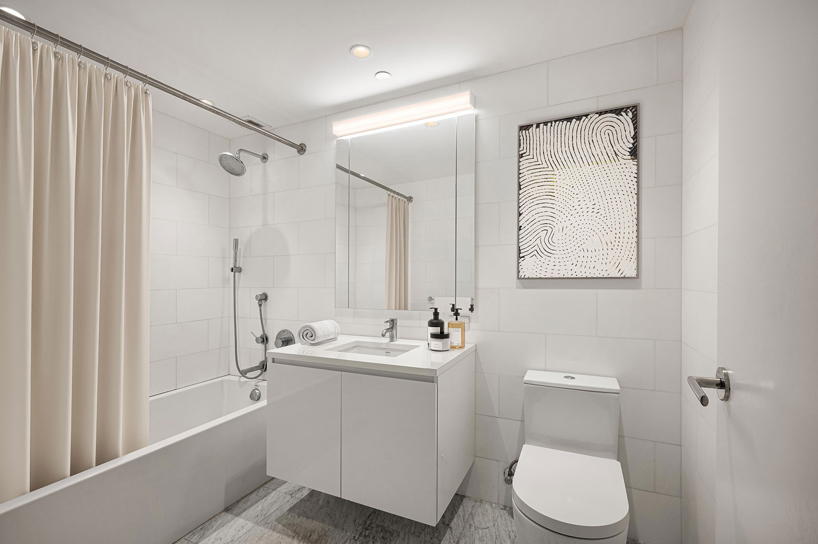 Modern bathroom with sleek finishes, and a bathtub/shower combo at 685 First Avenue, Murray Hill apartments for rent.